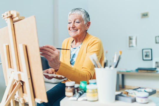 starsza kobieta malująca obraz