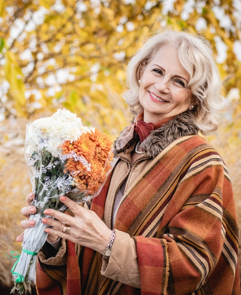 starsza kobieta z kwiatami w parku